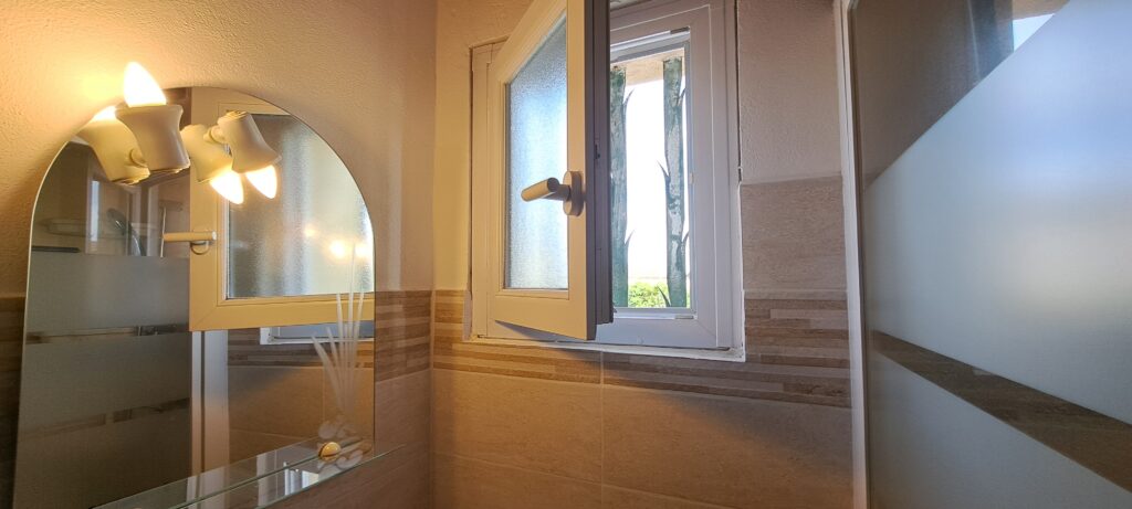Miroir et lavabo dans la salle d'eau de l'Oustau dei Aucèus.
