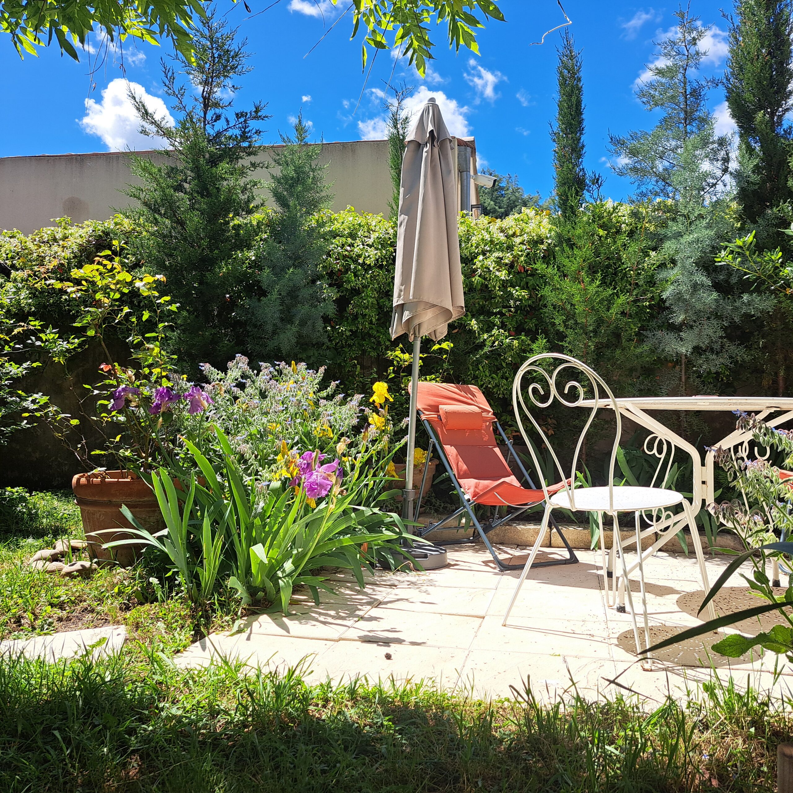 Terrasse fleurie sous le ciel bleu de Provence à L’Oustau dei Aucèus de Saint-Rémy-de-Provence, au printemps 2026.