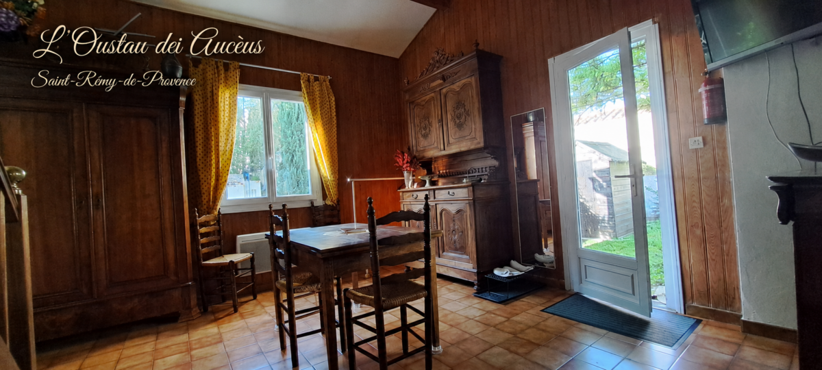 Pièce à vivre ensoleillée au volume cathédrale de L’Oustau dei Aucèus, avec salon, salle à manger, coin bureau et cuisine ouverte à Saint-Rémy-de-Provence.