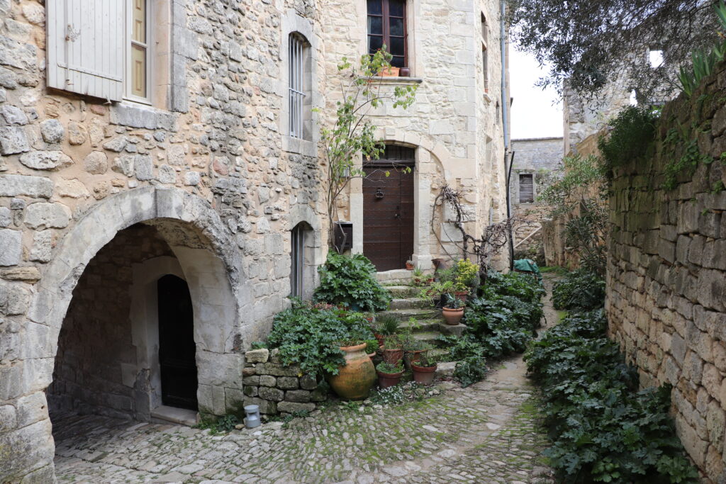 Passage dans les anciennes fortifications d'Oppède-le-Vieux avec demeure réhabilitée attenante, une découverte de destination pour une promenade depuis L'Oustau dei Aucèus