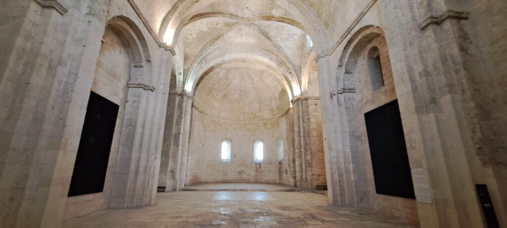 Nef de l'abbatiale Notre-Dame de Montmajour d'architecture romane avec de puissants piliers qui élèvent sa voûte, une église restée inachevée, proche de votre location L'Oustau dei Aucèus.